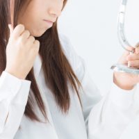髪のダメージを気にする女性